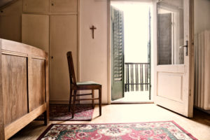 old room with chair in front of open balkony door,