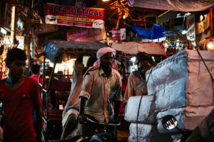 Rickshaw driver, loaded, Evening mood, many people, full streets Delhi, shops, India Rickshaw driver, loaded, Evening mood, many people, full streets Delhi, shops, India