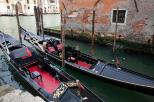 zwei schwarze Gondeln liegen in schmalem Kanal in Venedig zwei schwarze Gondeln liegen in schmalem Kanal in Venedig