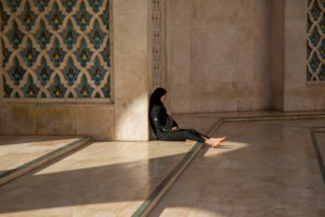 Local woman sits barefoot in in the vestibule of the Hassan-II. Mosque, Casablanca, Morocco Local woman sits barefoot in in the vestibule of the Hassan-II. Mosque, Casablanca, Morocco