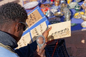 Ait Benhaddou, artist vendor, creative, Morocco, solar energy, power, commerce, young man, magnifying glass Ait Benhaddou, artist vendor, creative, Morocco, solar energy, power, commerce, young man, magnifying glass