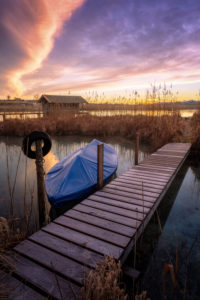 Jetty and boat on the lake shore at dawn Jetty and boat on the lake shore at dawn