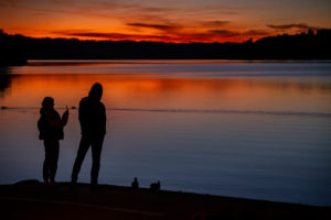 Silhouette of young woman and young man after sunset at Staffelsee in Murnau, blue country, Garmisch-Partenkirchen, Upper Bavaria, Bavaria, southern Germany, Germany Silhouette of young woman and young man after sunset at Staffelsee in Murnau, blue country, Garmisch-Partenkirchen, Upper Bavaria, Bavaria, southern Germany, Germany