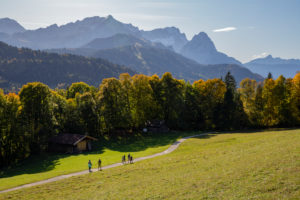 Autumn shot of family hiking near Pfeiffer-Alm near Garmisch-Partenkirchen, looking towards the Wetterstein Mountains with Alpspitze, Zugspitze, Waxensteinen and Berg Daniel (Austria), blue sky, hiking trail, trees, Garmisch-Partenkirchen, Upper Bavaria, Bavaria, southern Germany, Germany Autumn shot of family hiking near Pfeiffer-Alm near Garmisch-Partenkirchen, looking towards the Wetterstein Mountains with Alpspitze, Zugspitze, Waxensteinen and Berg Daniel (Austria), blue sky, hiking trail, trees, Garmisch-Partenkirchen, Upper Bavaria, Bavaria, southern Germany, Germany