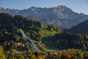 Large Olympic ski jump in Garmisch-Partenkirchen in autumn against Gudiberg and Partenkirchner Dreitorspitze in the Wetterstein Mountains, blue sky, trees, Garmisch-Partenkirchen, Upper Bavaria, Bavaria, southern Germany, Germany Large Olympic ski jump in Garmisch-Partenkirchen in autumn against Gudiberg and Partenkirchner Dreitorspitze in the Wetterstein Mountains, blue sky, trees, Garmisch-Partenkirchen, Upper Bavaria, Bavaria, southern Germany, Germany