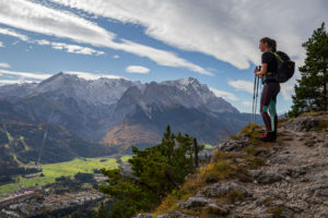 Young woman hiking towards Kramer looks out over Garmisch-Partenkirchen and Wetterstein Mountains with Alpspitze, Zugspitze, and Waxensteine, blue sky, clouds, trees, Garmisch-Partenkirchen, Upper Bavaria, Bavaria, southern Germany, Germany Young woman hiking towards Kramer looks out over Garmisch-Partenkirchen and Wetterstein Mountains with Alpspitze, Zugspitze, and Waxensteine, blue sky, clouds, trees, Garmisch-Partenkirchen, Upper Bavaria, Bavaria, southern Germany, Germany