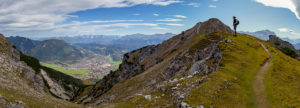 Panoramic photo of young woman hiking towards Kramer with a view over Garmisch-Partenkirchen, Ester Mountains, Karwendel Mountains and Wetterstein Mountains with Zugspitze, blue sky, clouds, hiking trail, rock, Garmisch-Partenkirchen, Upper Bavaria, Bavaria, southern Germany, Germany Panoramic photo of young woman hiking towards Kramer with a view over Garmisch-Partenkirchen, Ester Mountains, Karwendel Mountains and Wetterstein Mountains with Zugspitze, blue sky, clouds, hiking trail, rock, Garmisch-Partenkirchen, Upper Bavaria, Bavaria, southern Germany, Germany