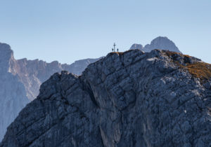 Two people at the summit cross at the Bernadeinkopf at the foot of the Alpspitze in the Wetterstein Mountains, blue sky, rock, Garmisch-Partenkirchen, Upper Bavaria, Bavaria, southern Germany, Germany Two people at the summit cross at the Bernadeinkopf at the foot of the Alpspitze in the Wetterstein Mountains, blue sky, rock, Garmisch-Partenkirchen, Upper Bavaria, Bavaria, southern Germany, Germany