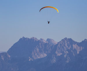 Paraglider against Karwendel Mountains, blue sky, Garmisch-Partenkirchen, Upper Bavaria, Bavaria, southern Germany, Germany Paraglider against Karwendel Mountains, blue sky, Garmisch-Partenkirchen, Upper Bavaria, Bavaria, southern Germany, Germany