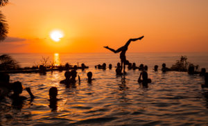 Young woman, young women, young men, acrobatics, infinity pool, swimming pool, sunset, sun, pool party, silhouette, sea, Central America, Costa Rica Young woman, young women, young men, acrobatics, infinity pool, swimming pool, sunset, sun, pool party, silhouette, sea, Central America, Costa Rica