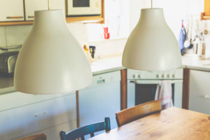 Innenansicht - zwei Lampen, Tisch und Stühle in einer kleinen Küche in einem Haus. Innenansicht - zwei Lampen, Tisch und Stühle in einer kleinen Küche in einem Haus.