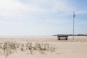 Eine Bank lädt zum Sitzen ein. Amrum, eine Insel in der deutschen Nordsee - Sand soweit das Auge reicht. Wittdün Eine Bank lädt zum Sitzen ein. Amrum, eine Insel in der deutschen Nordsee - Sand soweit das Auge reicht. Wittdün