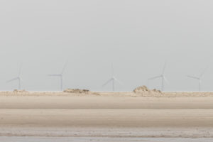 Fata Morgana am Wattenmeer - Flirrendes Licht - Blick über den Strand am Wattenmeer zu den Windrädern am Horizont. Fata Morgana am Wattenmeer - Flirrendes Licht - Blick über den Strand am Wattenmeer zu den Windrädern am Horizont.