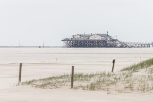 Weite, viel Sand und Pfahlbauten am Strand von St. Peter Ording, Wattenmeer, Nordsee Weite, viel Sand und Pfahlbauten am Strand von St. Peter Ording, Wattenmeer, Nordsee