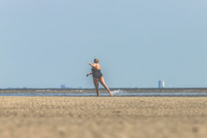 Woman in swimsuit dances, plays and enjoys the water on the Wadden Sea - detached Woman in swimsuit dances, plays and enjoys the water on the Wadden Sea - detached