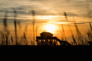 Colorful sunset on the North Sea - in the backlight of the sun a typical stilt house, pile dwellings, pile dwellings that defy the tides. Colorful sunset on the North Sea - in the backlight of the sun a typical stilt house, pile dwellings, pile dwellings that defy the tides.