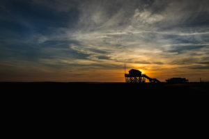 Colorful sunset on the North Sea - in the backlight of the sun a typical stilt house, pile dwellings, pile dwellings that defy the tides. Colorful sunset on the North Sea - in the backlight of the sun a typical stilt house, pile dwellings, pile dwellings that defy the tides.