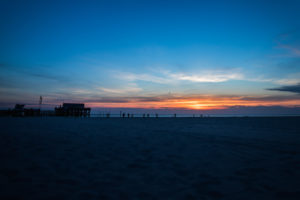 Relaxation on the Wadden Sea and on the beach of St. Peter Ording, North Sea at sunset, pile dwelling in the background Relaxation on the Wadden Sea and on the beach of St. Peter Ording, North Sea at sunset, pile dwelling in the background