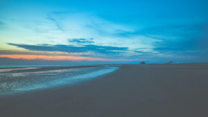 Stilt houses and beach chairs in the last sunlight. Wadden Sea, a lot of beach in St. Peter Ording, North Sea at sunset. Stilt houses and beach chairs in the last sunlight. Wadden Sea, a lot of beach in St. Peter Ording, North Sea at sunset.