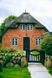 A garden gate in a stone wall on the property of a house on Sylt.