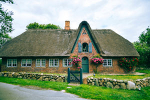 A garden gate in a stone wall on the property of a house on Sylt.