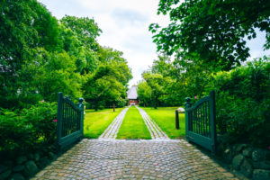 A garden gate and a long driveway to a house on Sylt.
