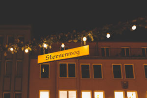 The Augsburger Christkindlesmarkt, Christmas market in Swabia at night. Sign saying Sternenweg