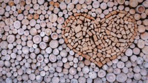 A wooden heart stacked in a pile of firewood for the fireplace or wood stove.