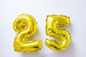 25 years - symbolic picture for an anniversary or a celebration - two golden balloons with the numbers two and five hang in an office.