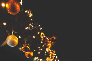 Golden and white Christmas baubles on a Christmas tree garland.