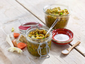 ayurvedic cuisine, vegetable broth paste in preserving jars with ingredients on wooden table