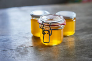 ayurvedic diet, steps to prepare homemade ghee from butter - filtered, still liquid ghee in three storage jars.