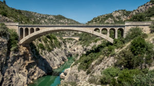Flussaufwärts der Pont du Diable über den Fluss Hérault. Die zweibogige Steinbrücke wurde im 11. Jahrhundert erbaut und war Teil des Pilgerwegs nach Santiago de Compostela. Weltkulturerbe der UNESCO. Monument historique. Flussaufwärts der Pont du Diable über den Fluss Hérault. Die zweibogige Steinbrücke wurde im 11. Jahrhundert erbaut und war Teil des Pilgerwegs nach Santiago de Compostela. Weltkulturerbe der UNESCO. Monument historique.