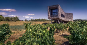 Domaine Castigno wine cellar at Assignan in summer. Has the shape of a bottle and the external walls are covered with cork. Domaine Castigno wine cellar at Assignan in summer. Has the shape of a bottle and the external walls are covered with cork.