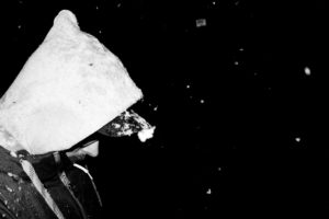 Man with hood and snowflakes, sideways, close-up, at night Man with hood and snowflakes, sideways, close-up, at night
