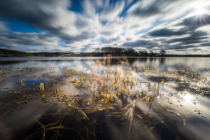 Sunrise over the lake in winter with drifting clouds Sunrise over the lake in winter with drifting clouds