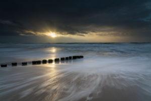 Baltic Sea in the evening light, long exposure, beach, sandstorm, blown groynes, moving clouds and rain showers with strong wind. Baltic Sea in the evening light, long exposure, beach, sandstorm, blown groynes, moving clouds and rain showers with strong wind.