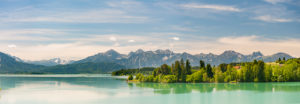 Panorama landscape in the Allgäu near Füssen with mountain range of the Alps at the Forggensee Panorama landscape in the Allgäu near Füssen with mountain range of the Alps at the Forggensee