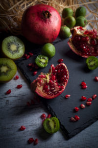 Pomegranate and kiwis on slate plate Pomegranate and kiwis on slate plate