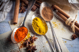 Spoon with spices, anise and cinnamon on old book pages Spoon with spices, anise and cinnamon on old book pages