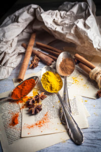 Spoon with spices, anise and cinnamon on old book pages Spoon with spices, anise and cinnamon on old book pages