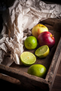 Apples and limes in wooden box Apples and limes in wooden box
