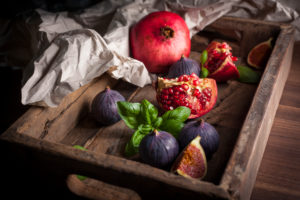 Pomegranate, figs and basil in wooden box Pomegranate, figs and basil in wooden box