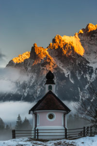 Die Kapelle Maria Königin am Lautersee bei Mittenwald. Im Hintergrund Alpenglühen am Karwendelgebirge. Die Kapelle Maria Königin am Lautersee bei Mittenwald. Im Hintergrund Alpenglühen am Karwendelgebirge.