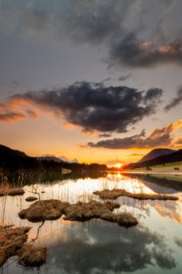Spring sunset at Geroldsee on the shore with reed island with clouds Spring sunset at Geroldsee on the shore with reed island with clouds