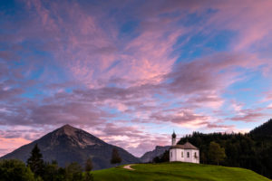 Das kleine Annakircherl, eine kleine Kapelle auf einem Hügel in Achenkirch am Rend des Karwendel inden Alpen, Tirol nach Sonnenuntergang. Lila und Blautöne dominieren den Abendhimmel. Im Hintergrund die Berge. Das kleine Annakircherl, eine kleine Kapelle auf einem Hügel in Achenkirch am Rend des Karwendel inden Alpen, Tirol nach Sonnenuntergang. Lila und Blautöne dominieren den Abendhimmel. Im Hintergrund die Berge.