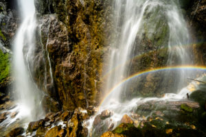 Regenbogen am Dalfazer Wasserfall unterhalb des Dalfazer Klettersteiges am Achensee im Rofan Gebirge. Wasser stürzt an der Felswand hinab und bildet im Sonnenschein einen wunderbaren kleinen doppelten Regenbogen. Regenbogen am Dalfazer Wasserfall unterhalb des Dalfazer Klettersteiges am Achensee im Rofan Gebirge. Wasser stürzt an der Felswand hinab und bildet im Sonnenschein einen wunderbaren kleinen doppelten Regenbogen.