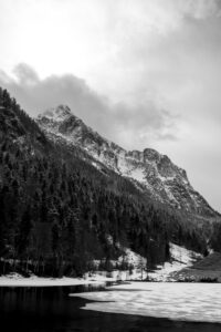 Broken up ice at Ferchensee in the Bavarian Alps above Mittenwald in early spring. In the background the Wetterstein mountains with dense clouds and fresh snow.