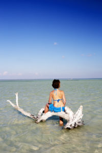 Female Tourist sunbathing on an idyllic beach in Holbox Female Tourist sunbathing on an idyllic beach in Holbox