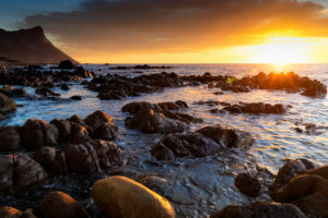 Sunset at False Bay (South Africa) with clouds and boulders on the foreground, Western Cape, South Africa Sunset at False Bay (South Africa) with clouds and boulders on the foreground, Western Cape, South Africa